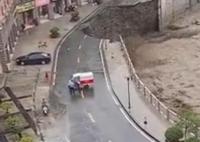8月22日,陕西暴雨致一小区门口道路垮塌成陡崖,路面和泥土被河水冲走,居民远远拍下